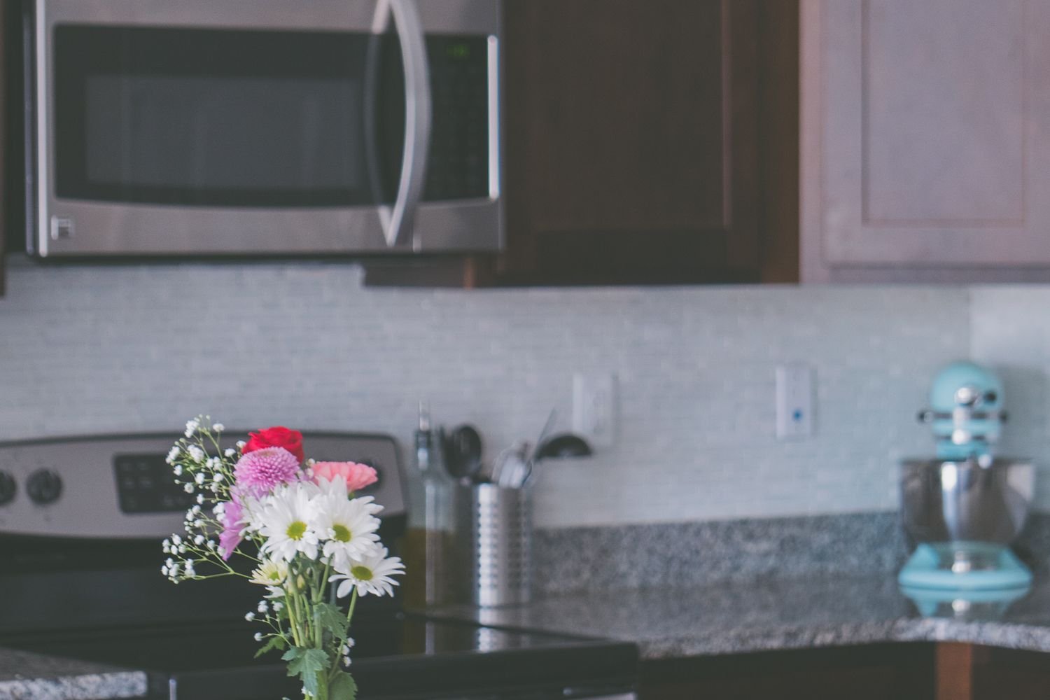 Stone countertops and a crafted backsplash — durable surfaces chosen for daily cooking and easy upkeep.